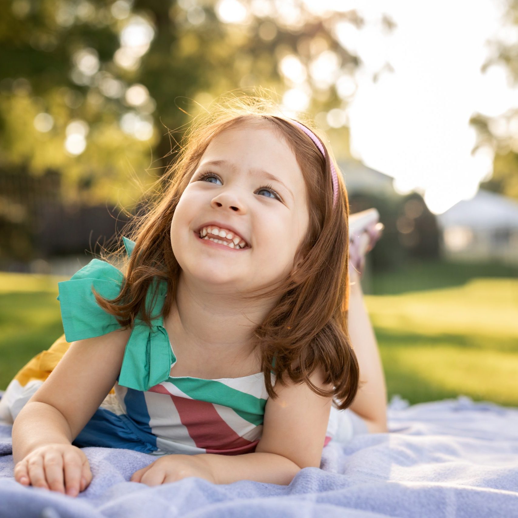 Girl in dress laying on blanket and laughing